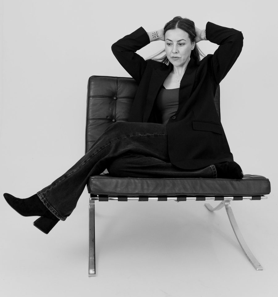 Adele Molyneux in a black leather chair
